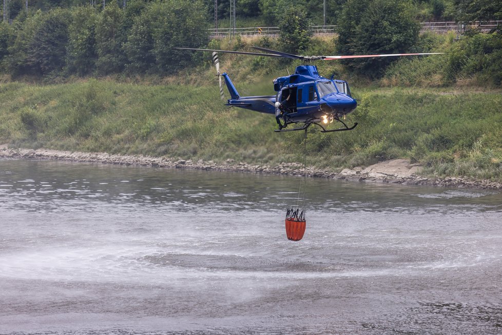 Policejní vrtulník při hašení požáru v Českém Švýcarsku. (26.7.2022)