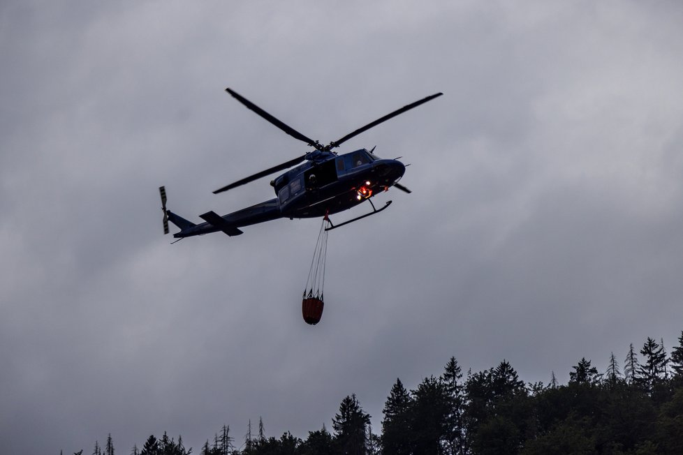 Policejní vrtulník při hašení požáru v Českém Švýcarsku. (26.7.2022)