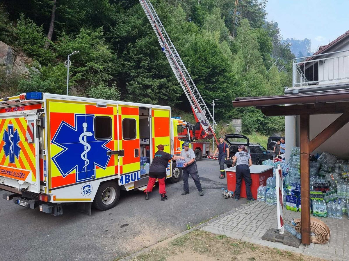 Záchranáři z Řevnic přivezli do Hřenska desítky balíků pitné vody a tatranky.