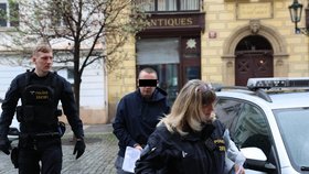 Policisté přivádějí muže (29), který je podezřelý ze zapálení stájí na Císařském ostrově. V ohni uhynulo 8 koní. (14. duben 2023)