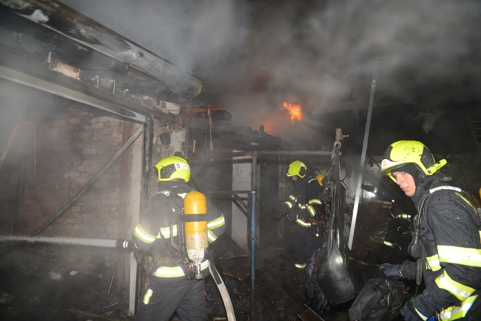 Požár domu v ulici Na Slatinách v Praze, při kterém hořelo i auto v garáži.