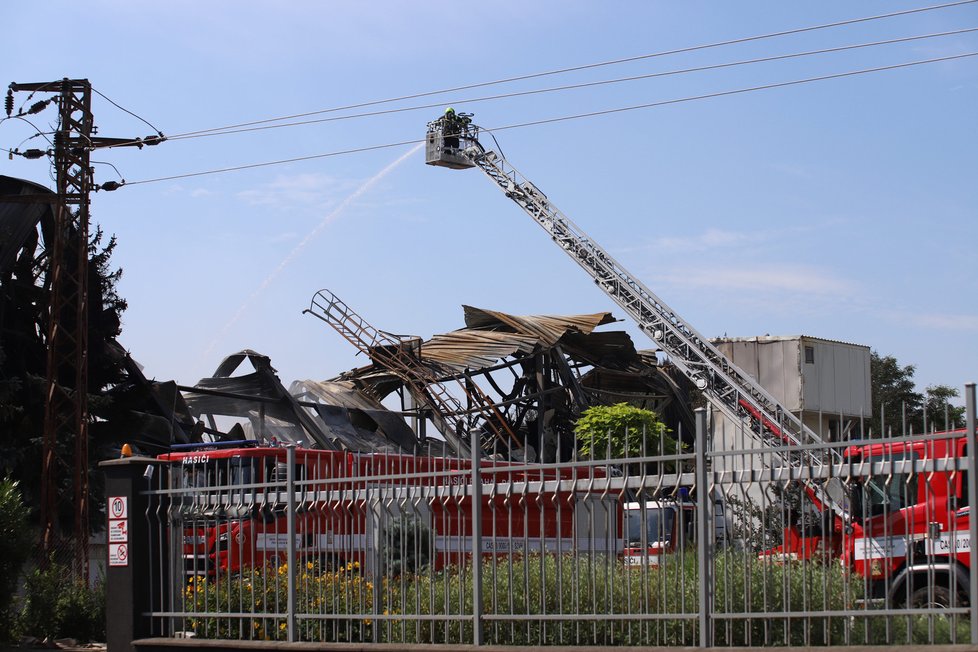 Požár haly v Uhříněvsi si vyžádal přítomnost hasičů i druhého dne. (26. červenec 2021)