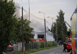 Při požáru haly v Uhříněvsi zasahovalo 23 jednotek profesionálních a dobrovolných hasičů. (25. července 2021)