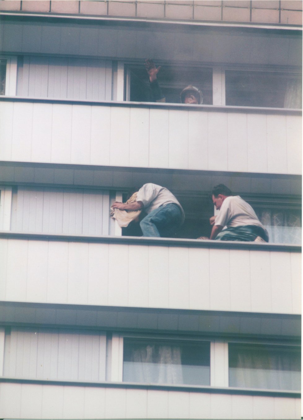 Z této fotografie se doslova tají dech. Ukazuje skupinku hostů v těch nejvyšších patrech budovy, kteří se před zkázonosným dávivým dýmem snažili schovat na úzkých římsách hotelu.