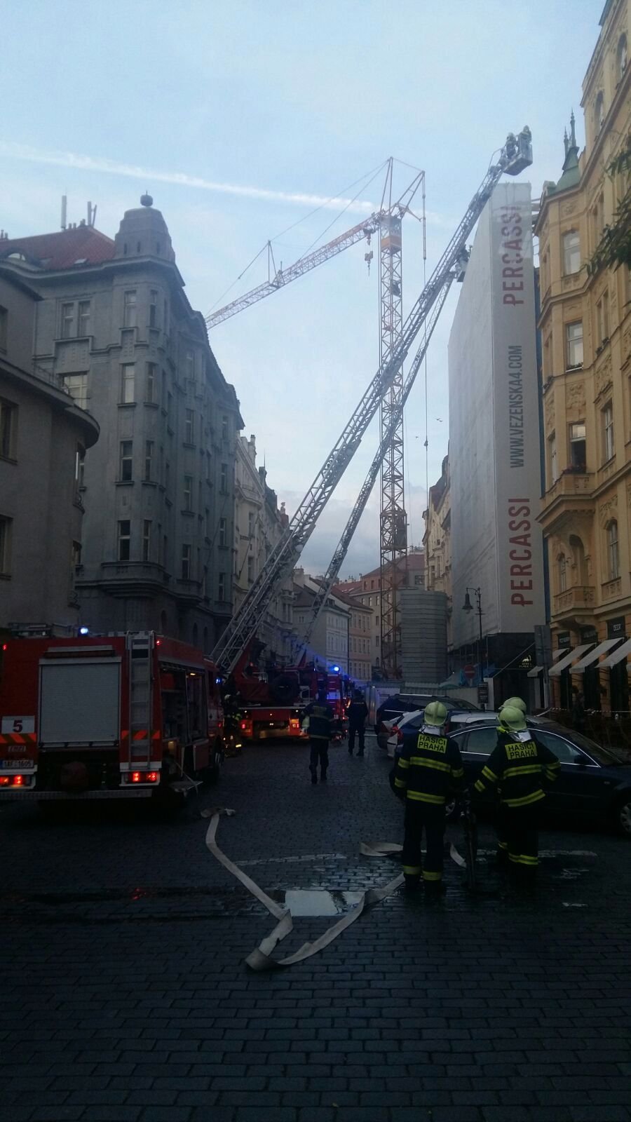 Sedm hasičských jednotek hasilo požár v centru Prahy: Opravovanému domu chytla střecha.