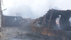 Vyhořelá hala v neděli ráno. Škoda je odhadem 4 miliony korun, příčinu ohně zjišťují vyšetřovatelé hasičů.