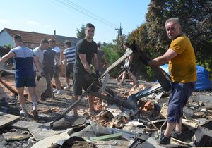 Syn Matěj a otec Petr Žídkovi při odklízení sutin, v němž se jim po požáru proměnil dům a stolárna.
