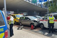 Nehoda na Smíchově komplikuje dopravu: Srazila se dvě auta a převozová sanitka, zranil se muž (76)