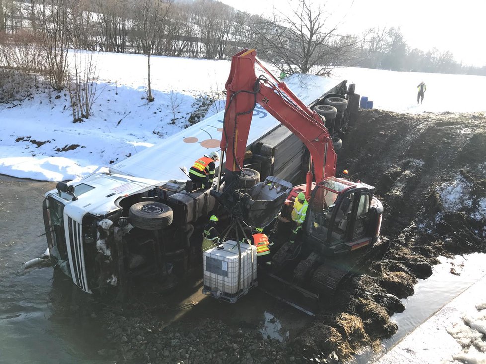 Na dálnici D5 se zřítil kamion do řeky. Na místo přijeli hasiči, kteří odčerpávají naftu z vozu.