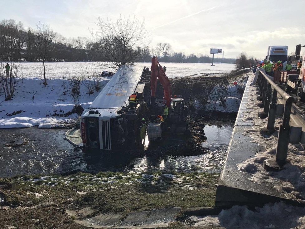 Na dálnici D5 se zřítil kamion do řeky. Na místo přijeli hasiči, kteří odčerpávají naftu z vozu.