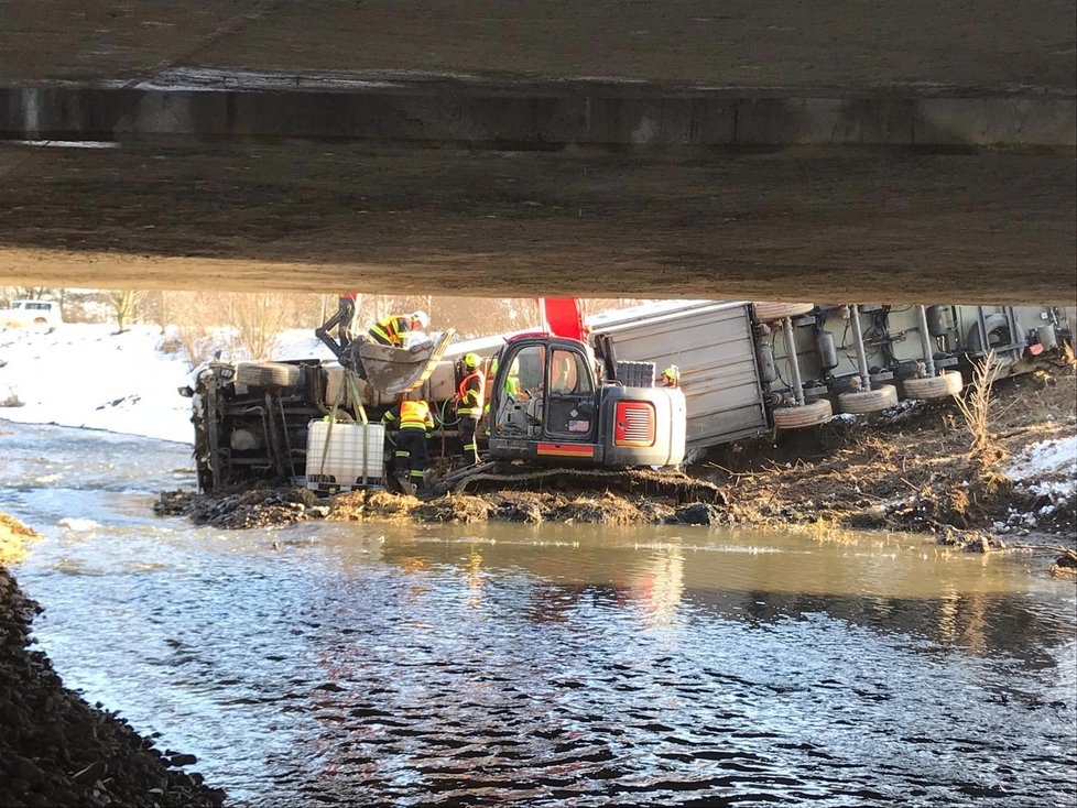 Na dálnici D5 se zřítil kamion do řeky. Na místo přijeli hasiči, kteří odčerpávají naftu z vozu.