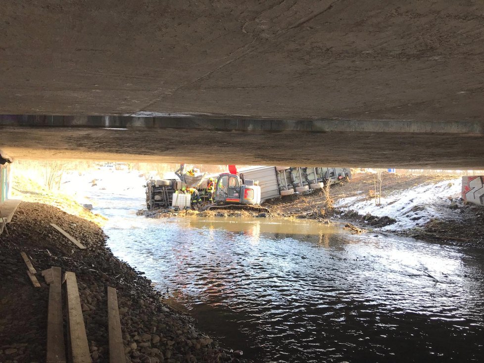 Na dálnici D5 se zřítil kamion do řeky. Na místo přijeli hasiči, kteří odčerpávají naftu z vozu.