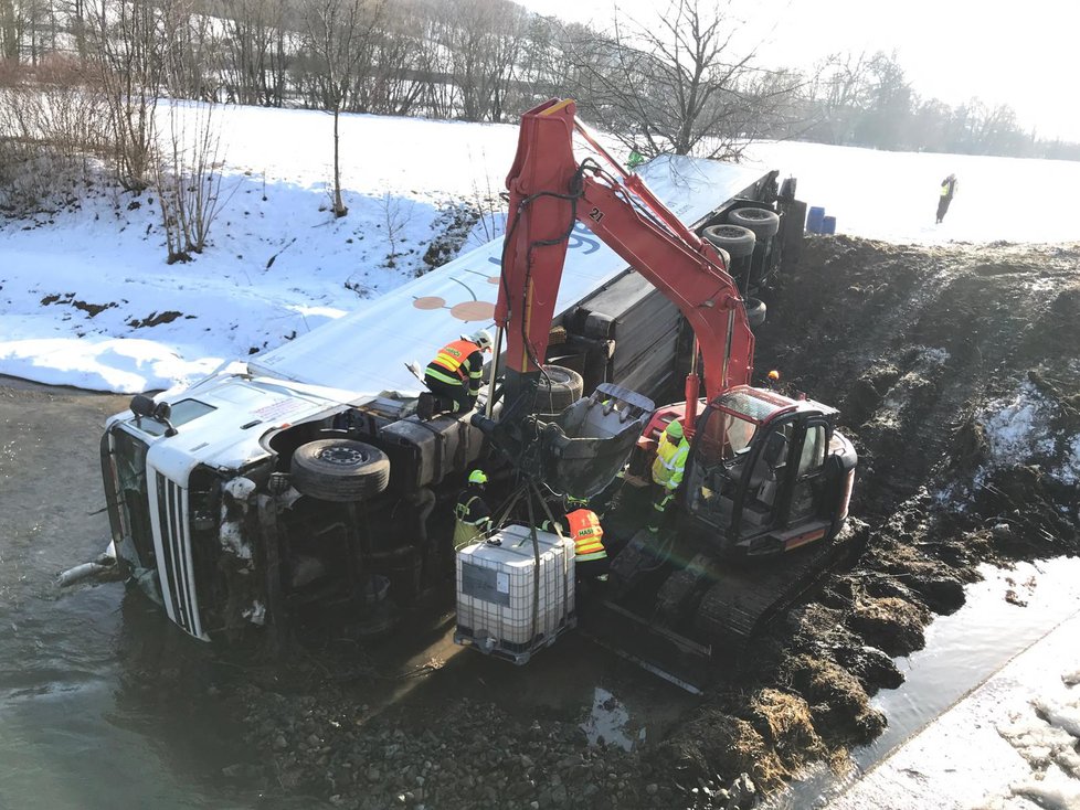 Na dálnici D5 se zřítil kamion do řeky. Na místo přijeli hasiči, kteří odčerpávají naftu z vozu.