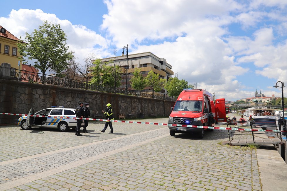 Hasiči spolu s policisty pátrají u Čechova mostu v centru Prahy po muži, který z mostu skočil (30. 5. 2021).