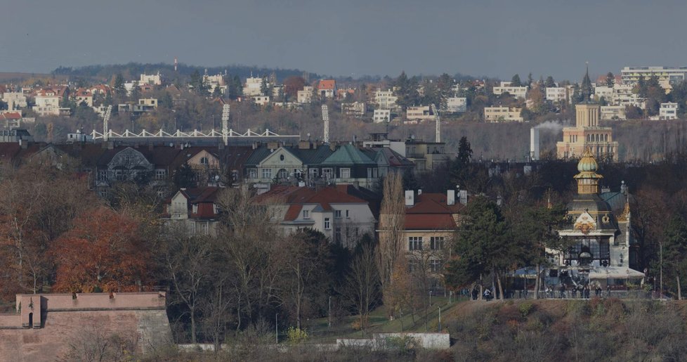 Na západě Prahy vykukuje další architektonický klenot. Střecha hotelu Internacional, který je v Podbabě. O něco dál lze vidět světla stadionu Juliska. První objekt je vzdálen 3,13 a druhý 3,6 kilometru.