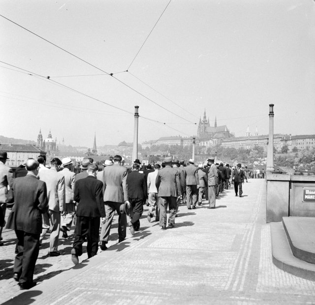 Lidé kráčejí po Mánesově mostě roku 1942. Směřují na Pražský hrad, kde proběhl smuteční obřad po atentátu Reinharda Heydricha.
