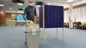 Členka simulované volební komise dezinfikuje psací potřeby v instruktážním spotu, který 4. září 2020 natočilo ministerstvo vnitra před říjnovými krajskými a senátními volbami.