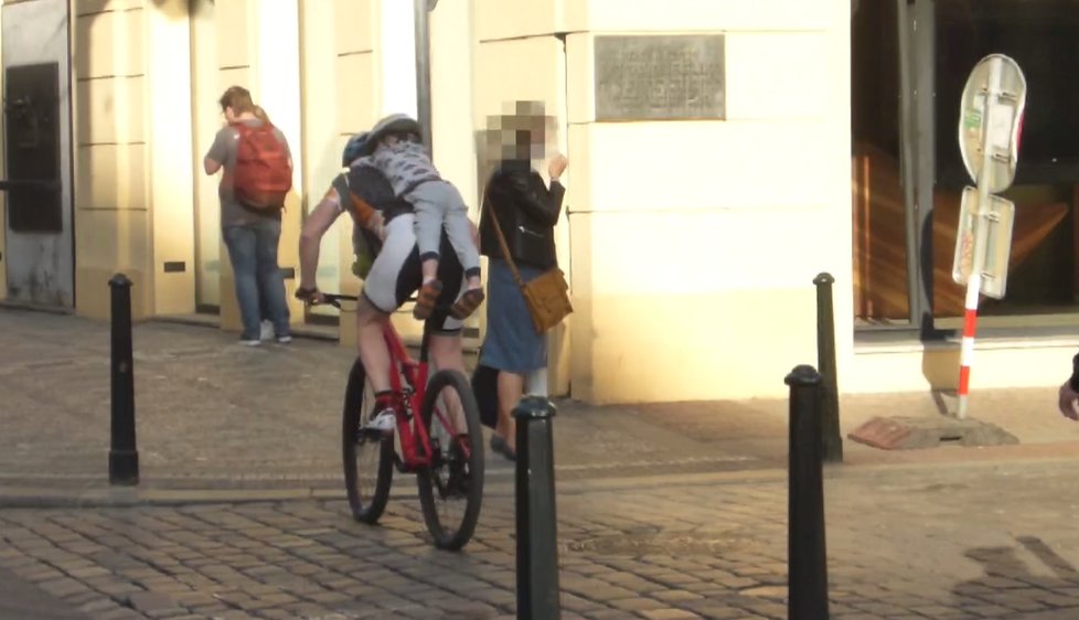 Muž jel ulicemi Prahy na kole, na krku mu visel čtyřletý syn.