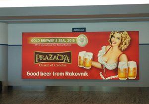 Na pražském letišti vítá cestovatele Pražačka s pořádným výstřihem.