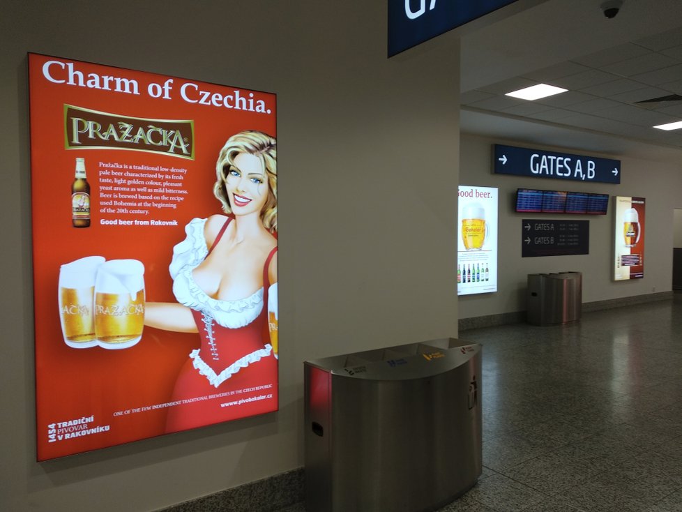 Na pražském letišti vítá cestovatele Pražačka s pořádným výstřihem.