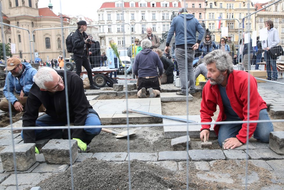 Sochař Váňa se spolupracovníky vrací kostky na Staroměstském náměstí zpátky.