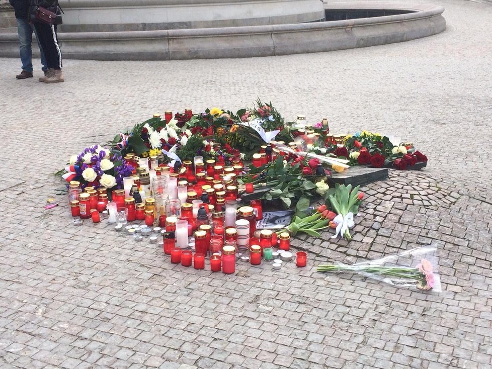Lidé pokládají kytky, věnce a svíce na místo, kde se Jan Palach zapálil.