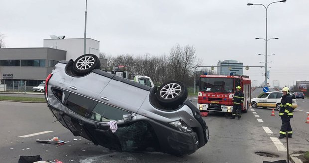 Automobil skončil na střeše. Záchranka odvezla zraněného muže a ženu do nemocnice na Vinohradech.