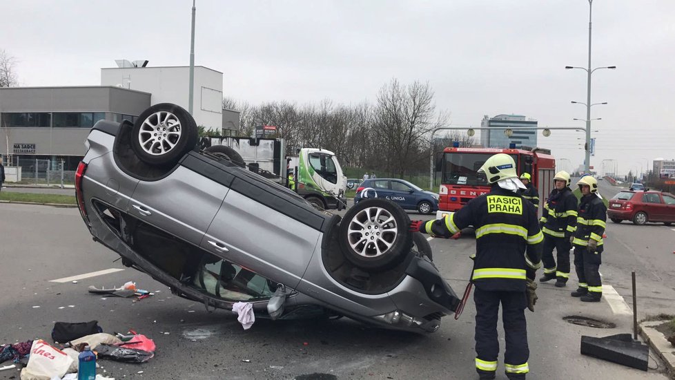 Automobil skončil na střeše. Záchranka odvezla zraněného muže a ženu do nemocnice na Vinohradech.