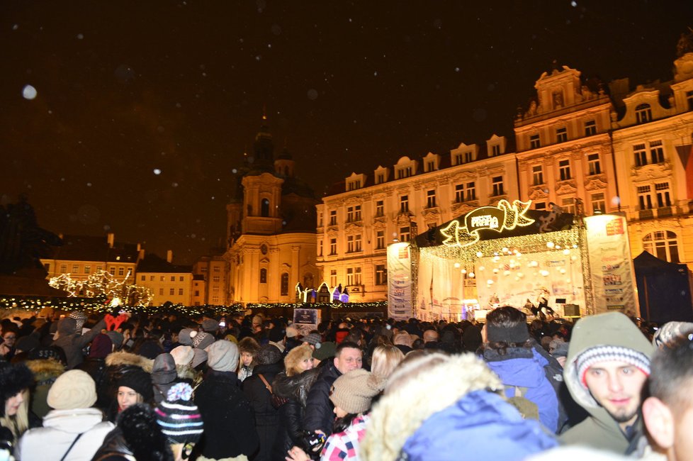 Na davy na Staroměstském náměstí se snáší sníh.