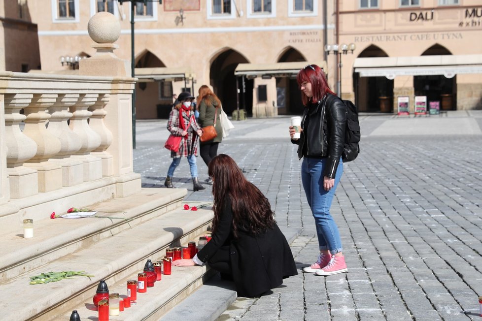 Lidé na Staroměstské náměstí přicházejí zapálit svíčky za zemřelé s covidem. (25. března 2021)