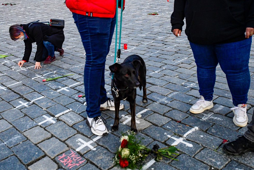 Lidé na Staroměstské náměstí přicházejí zapálit svíčky za zemřelé s covidem. (25. března 2021)