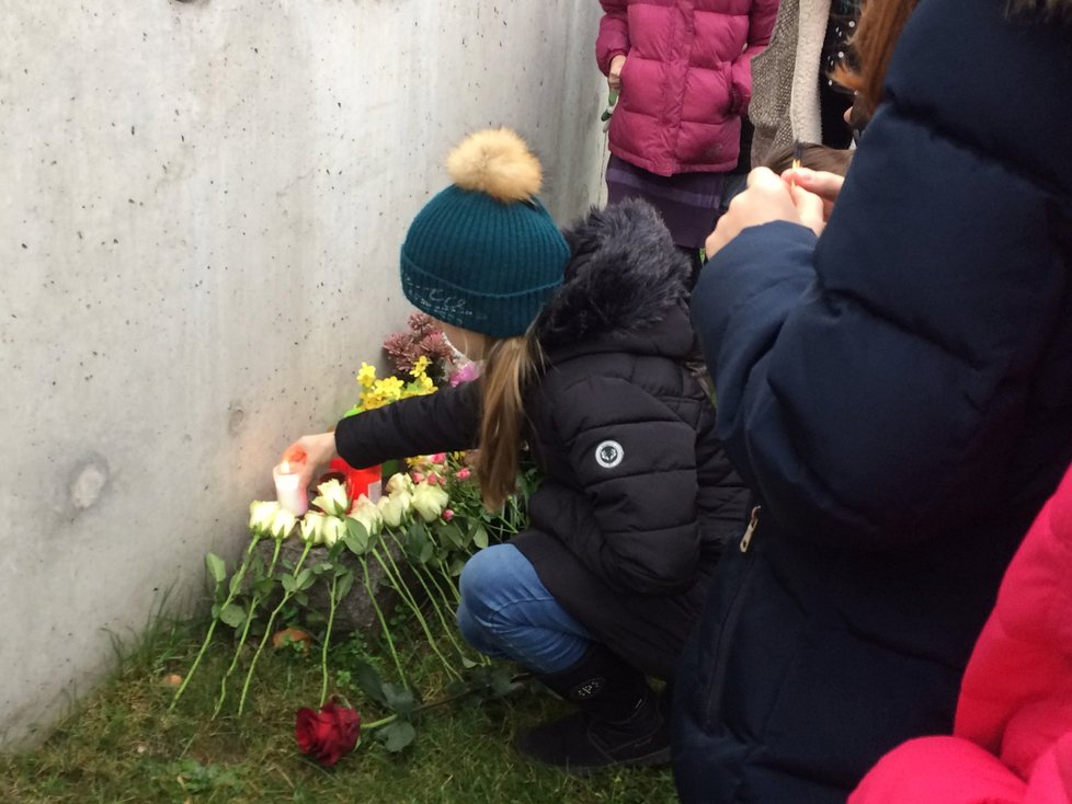 Holčička zapaluje svíčku na pomníku zesnulé Anežky (8).