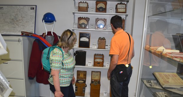 Návštěvníci muzea si prohlížejí historické měřicí přístroje.
