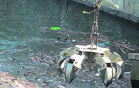 Vodohospodáři musejí těžit z přehrady tuny odpadků těžkou technikou.