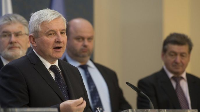 Premiér Jiří Rusnok na tiskové konferenci po schůzi vlády. Zleva v pozadí přihlížejí ministři Martin Holcát, Martin Pecina a Jiří Cienciala.