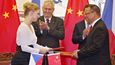 Prezident Miloš Zeman (v pozadí vlevo) s čínským prezidentem Si Ťin-pchingem (v pozadí vpravo) přihlížejí 27. října v Pekingu podpisu smlouvy o výrobě seriálu Krteček a panda, kterou za českou stranu podepsala vnučka výtvarníka Zdeňka Milera Karolína Milerová (vlevo)