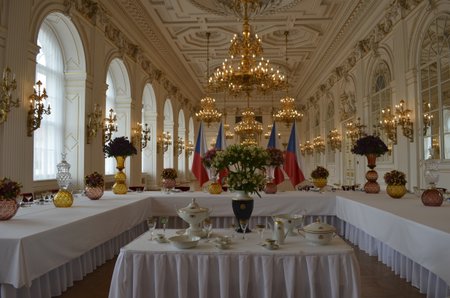 Takto jedí politici, prezidenti a zahraniční delegace. Na stolech jsou sklenice z českého skla a jídlo se podává v českému porcelánu. Uprostřed fotografie se nachází dobový porcelán, ze kterého jedl už Tomáš Garrigue Masaryk nebo třeba Emil Hácha.