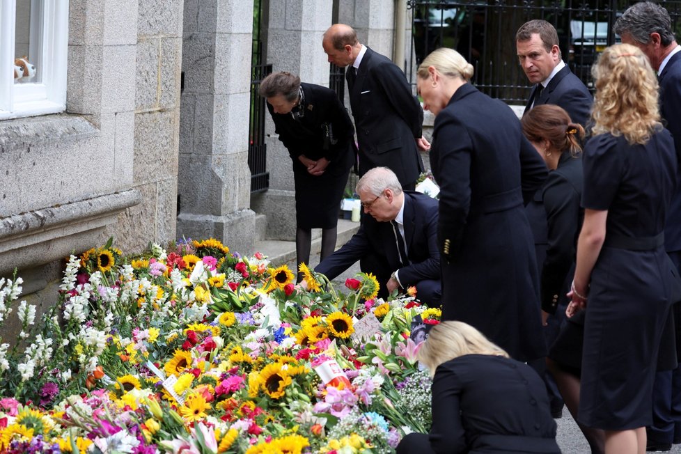 Členové královské rodiny si prohlíží květiny a vzkazy pro královnu před zámkem Balmoral.