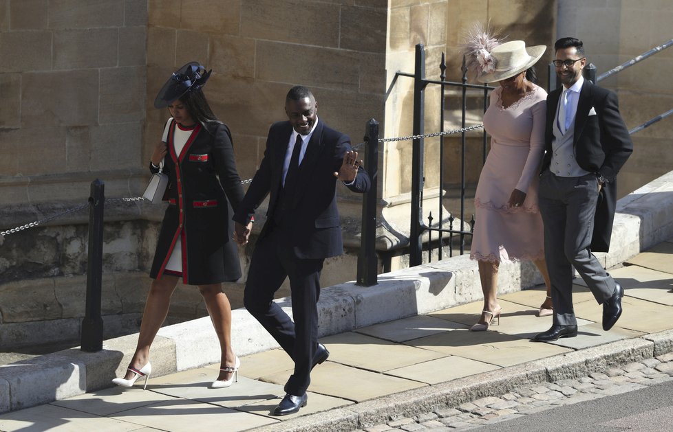 Herec Idris Elba a za ním Oprah Winfrey na svatbě v Británii