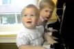 Malí princové hrají na klavír. Rodiče Charles a Diana přihlížejí
