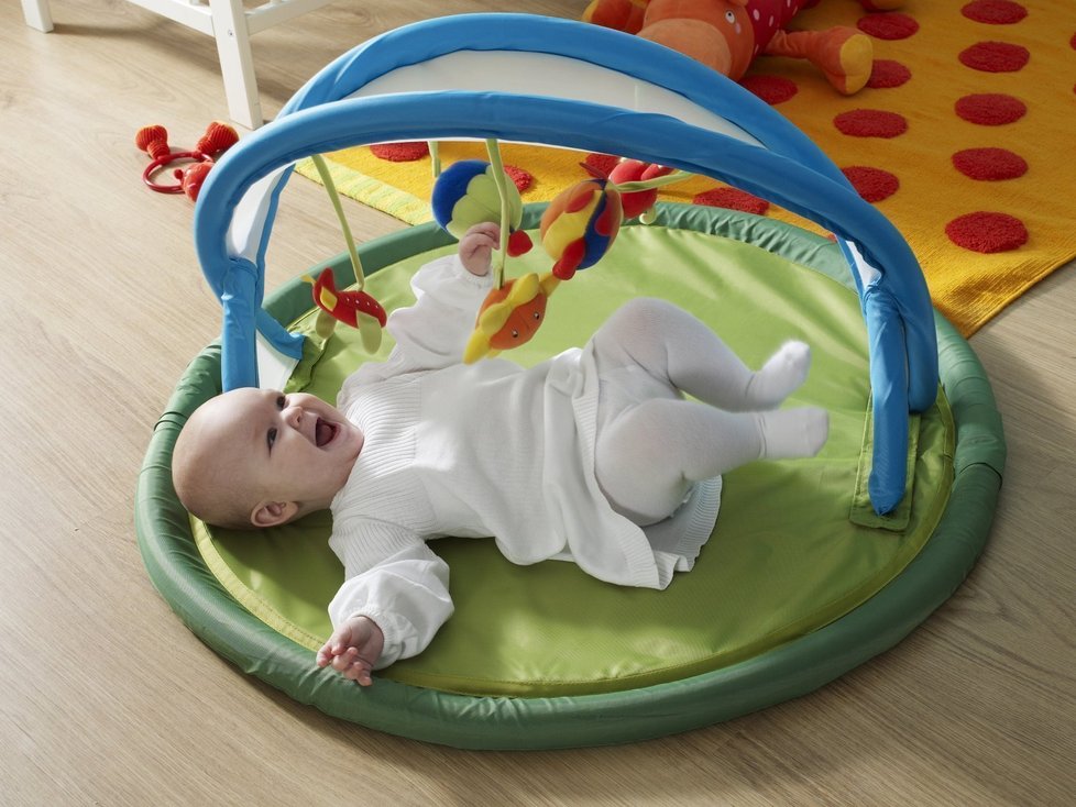 Hrazda LEKA pro miminka od narození stimuluje pohybem a kotrasty jejich zrak, po odstranění oblouku lze použít jako přebalovací podložku, IKEA, 799 Kč