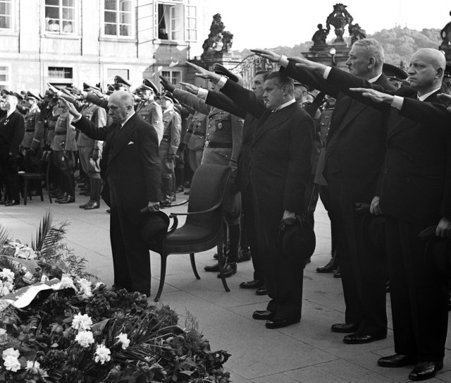 Prezident Emil Hácha hajluje na počest zavražděného říšského protektora Reinharda Heidrycha v r. 1942.