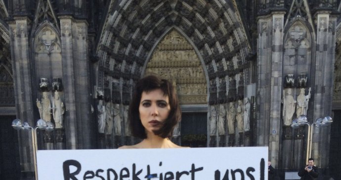 Švýcarská umělkyně Milo Moire s transparentem, se kterým nahá volala po respektu k ženám. Postavila se přitom v pátek před katedrálu v Kolíně nad Rýnem.