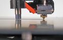 Tryska 3D tiskárny pokládá roztavený filament na podložku