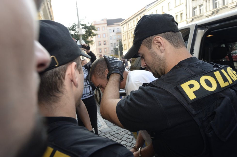 Policisté předvádějí Marka P. k soudu.