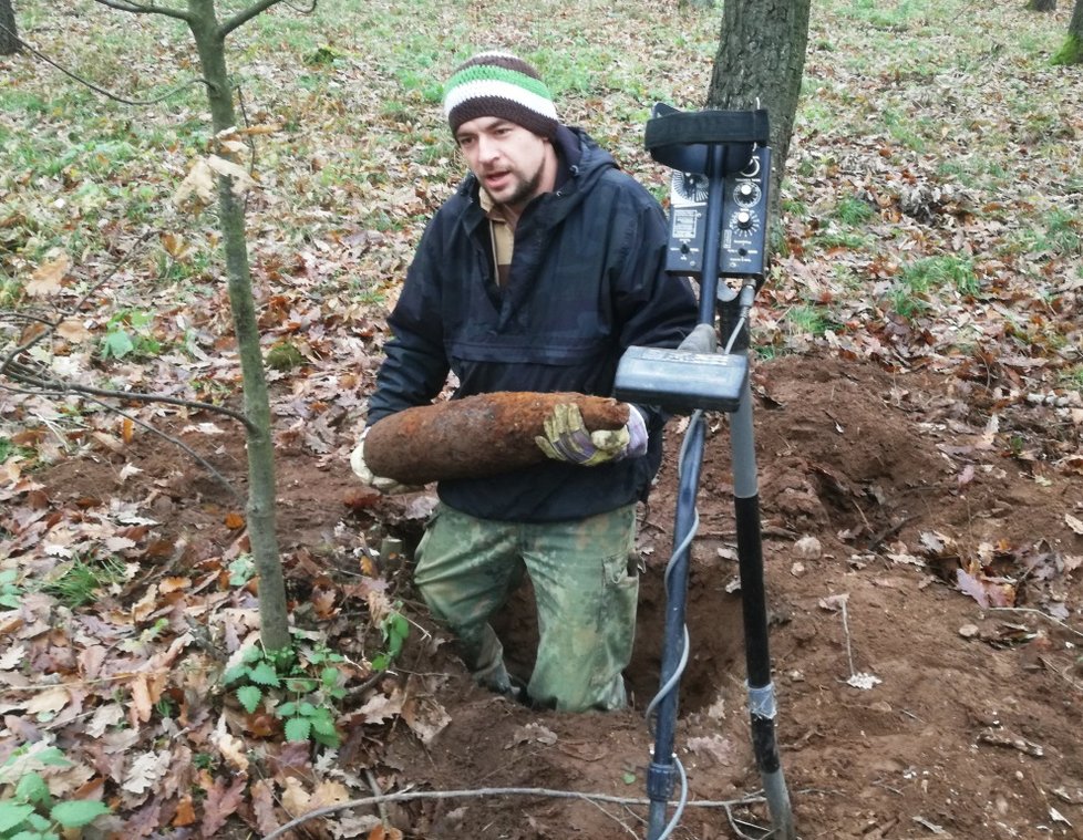 Pyrotechnik společnosti Borgata Jiří Chládek ml. vyzvedává z půdy Bořího lesa u Břeclavi dělostřelecký granát ráže 152 mm.