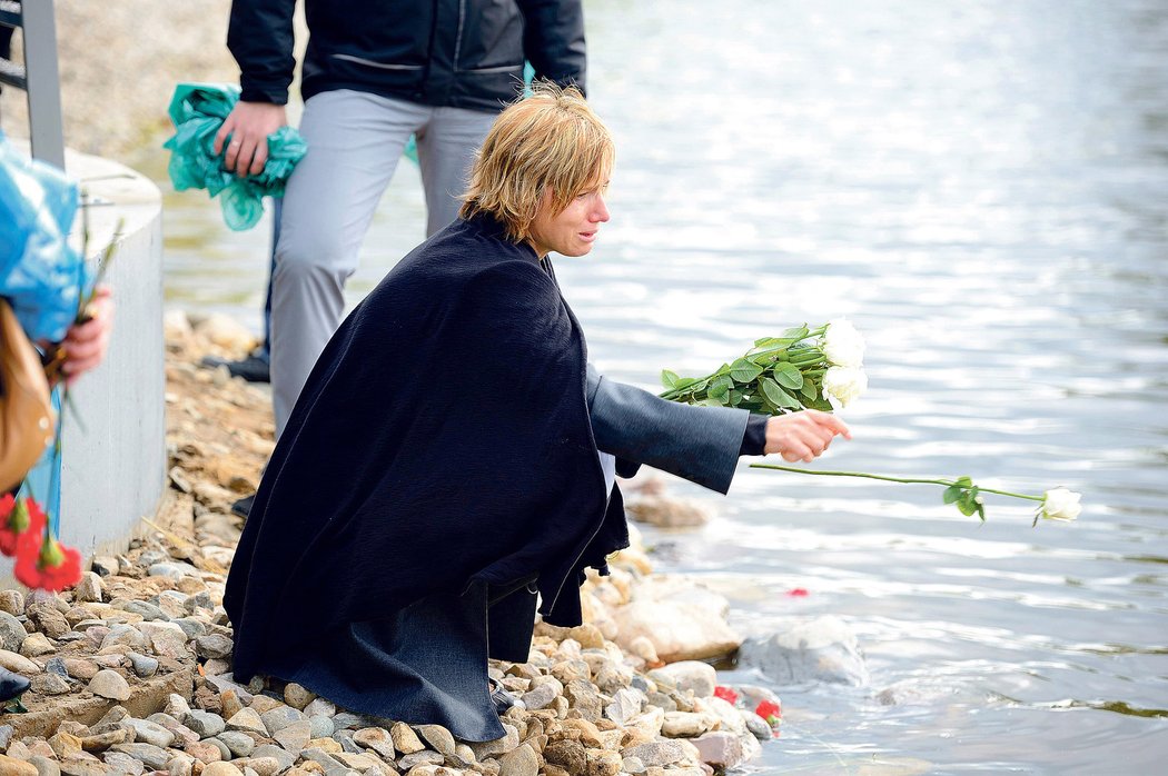 Kateřina, vdova po Karlu Rachůnkovi, hází bílé růže do říčky Tušonočka, kam se před rokem zřítilo letadlo s hokejisty