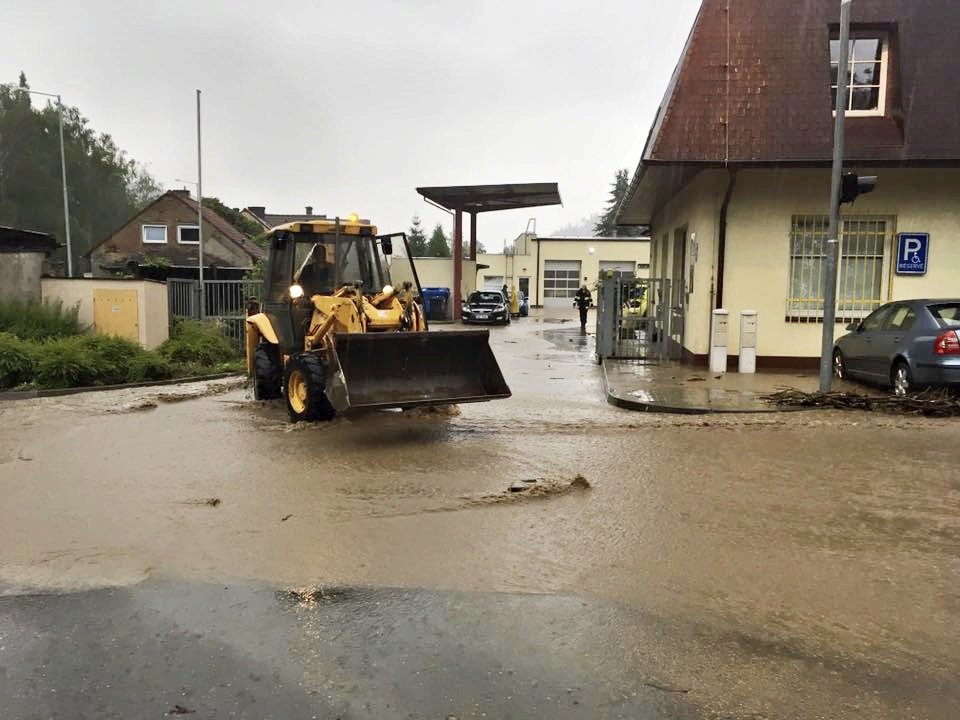 Extrémní déšť v Radotíně vytopil potok, voda se dostala přes hráz rybníka.