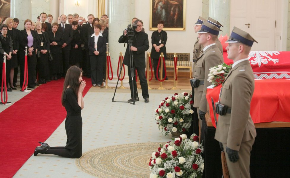 Pohřeb Lecha Kaczyńského. Marta v modlitbě klečí před rakvemi svých rodičů.