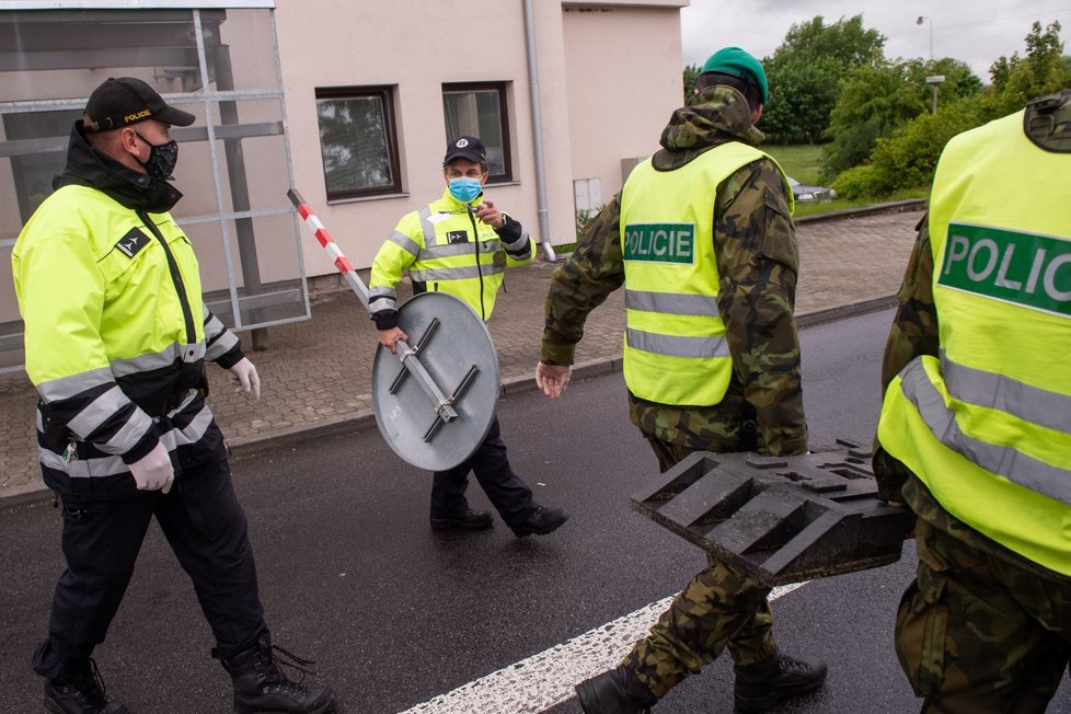 Policisté a vojáci 5. června 2020 odklízejí dopravní značky z dočasného kontrolního stanoviště na česko-rakouských hranicích v Dolním Dvořišti. Od 12:00 téhož dne Česká republika zcela uvolnila cestování mezi oběma státy, Rakousko tak učinilo o den dříve.